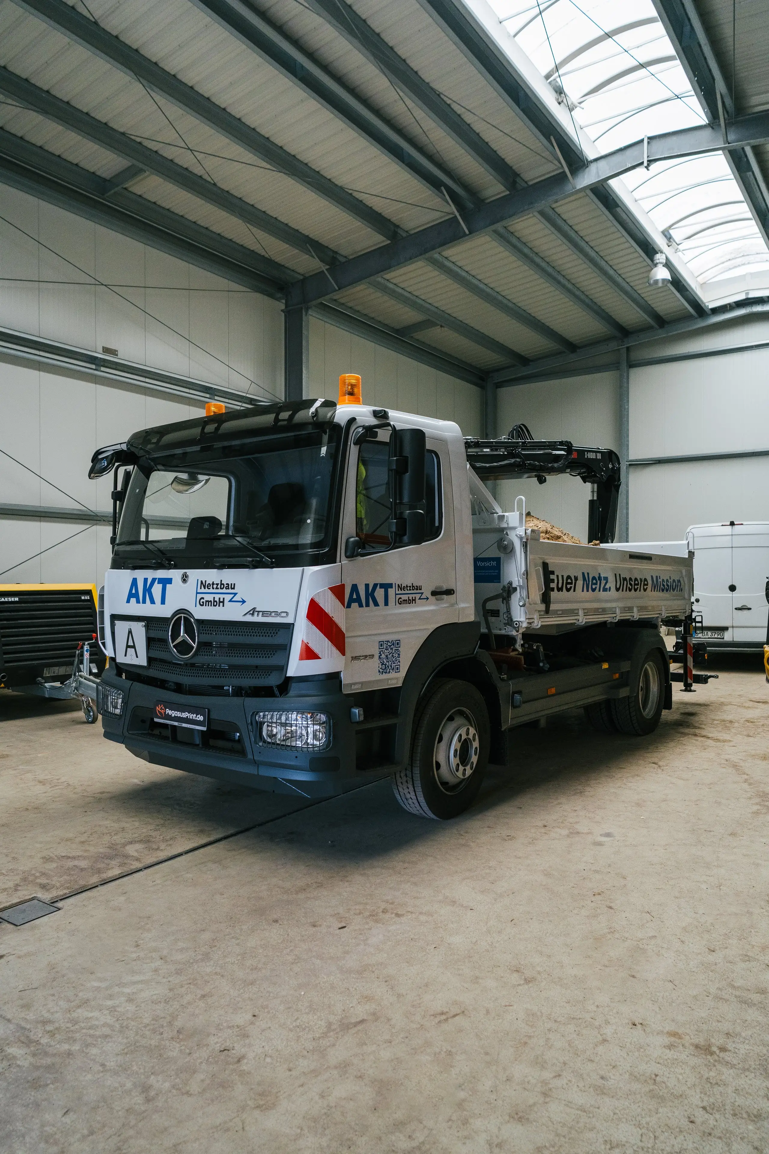 Beschrifteter AKT Netzbau LKW in der Seitenansicht