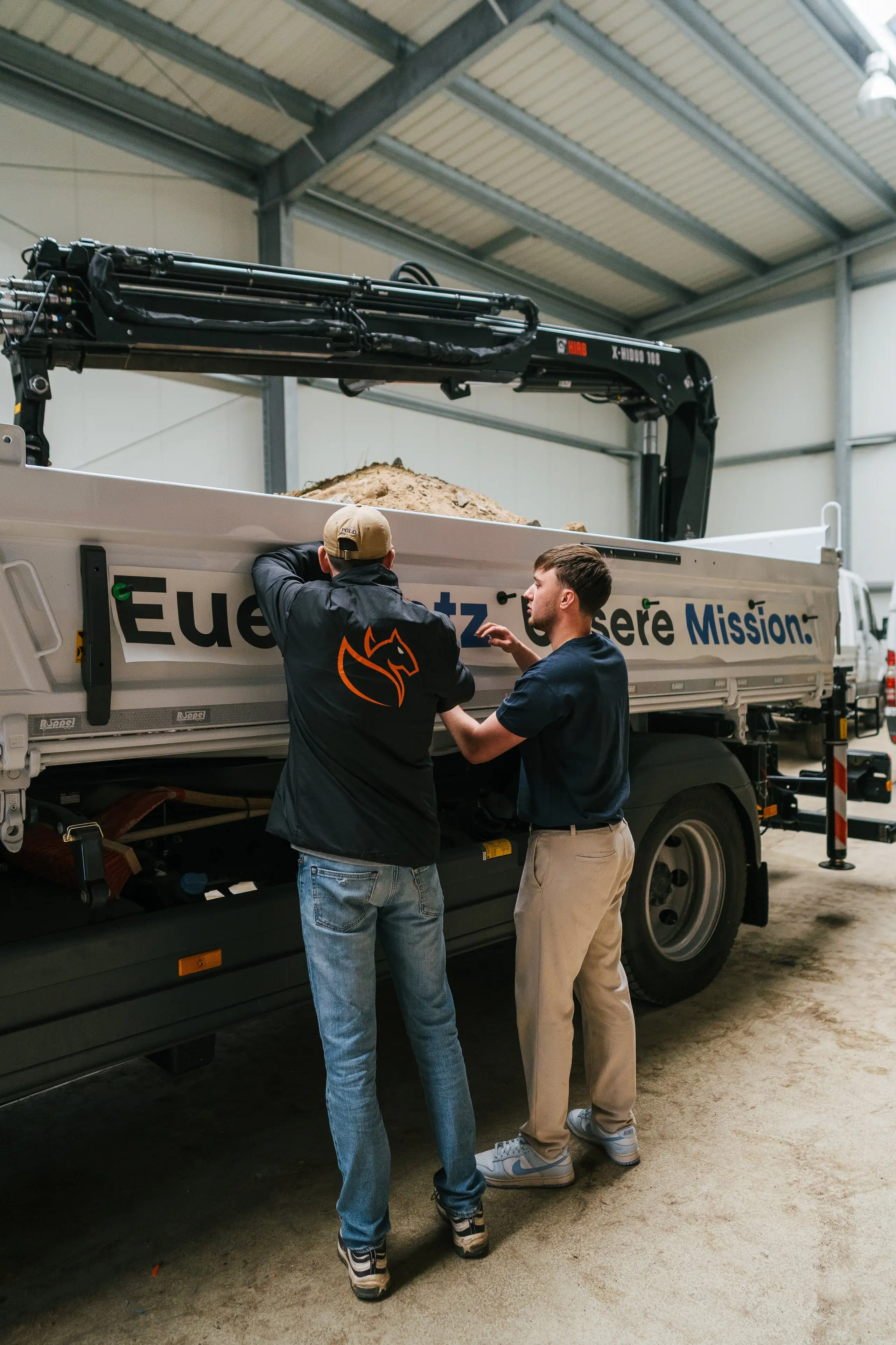 AKT-Team am LKW mit Ladekran während der Übergabe