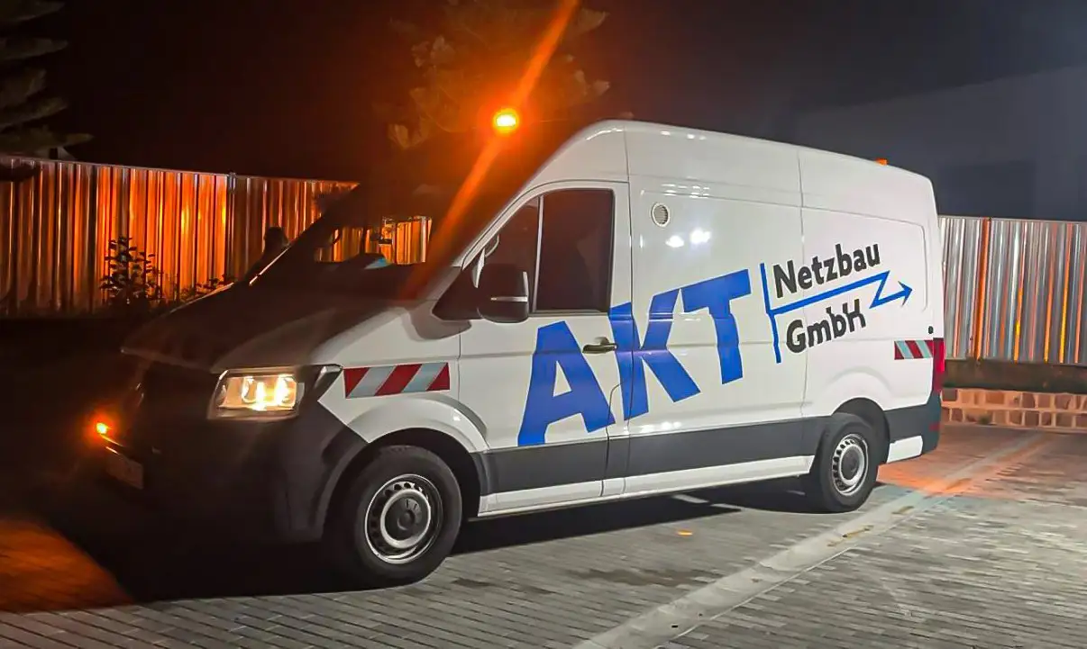 Beschrifteter AKT Netzbau Transporter bei Nacht