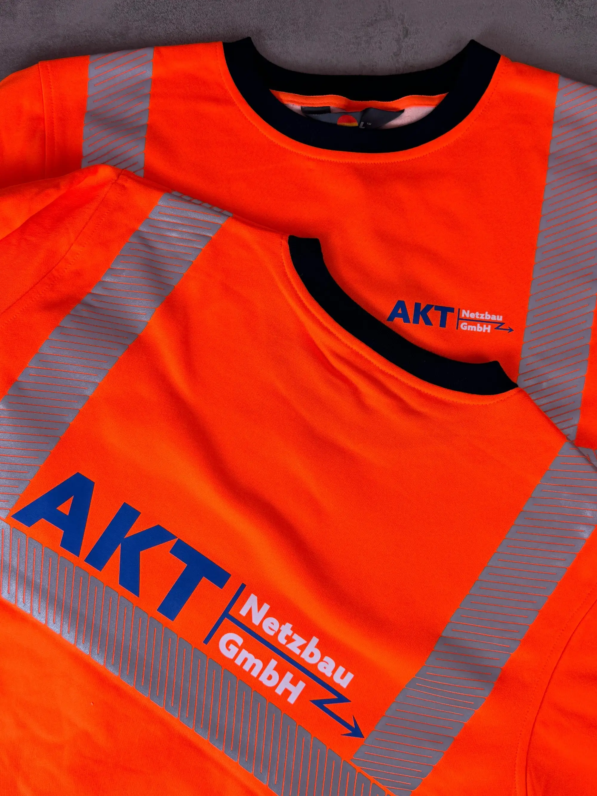 Orange Warnweste mit AKT Netzbau Logo