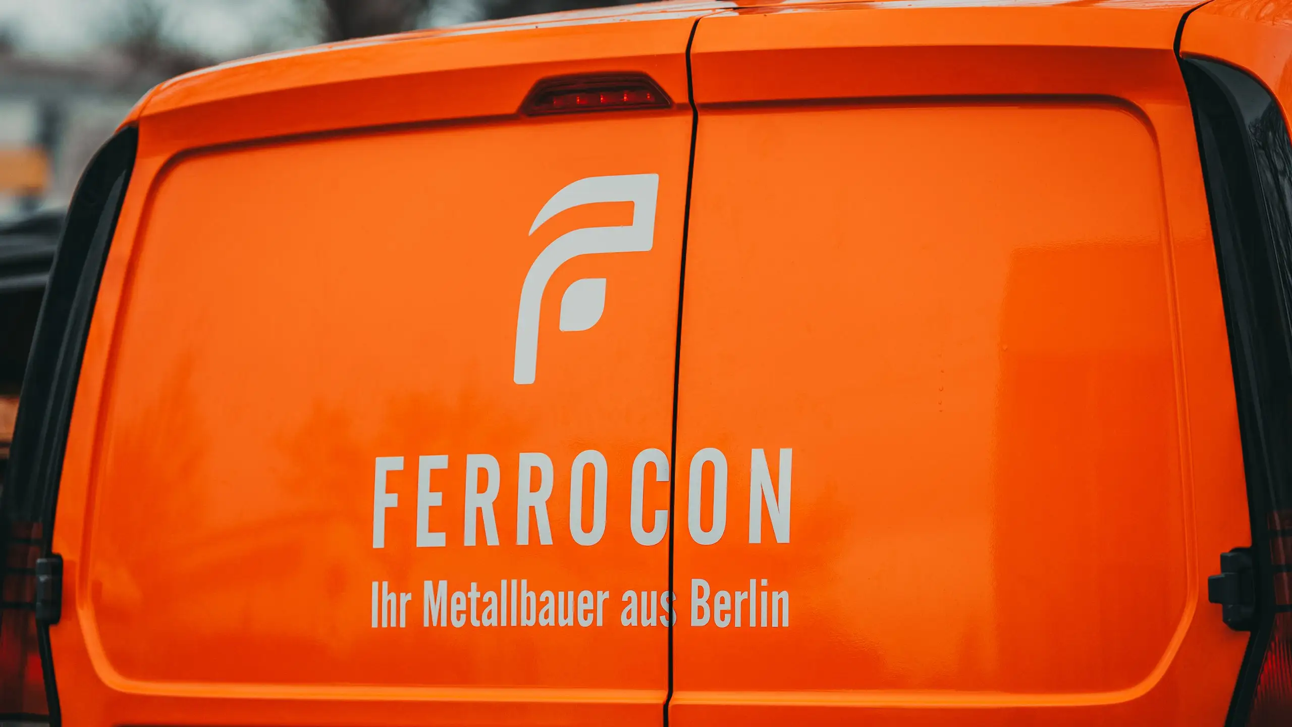 Orange folierte Hecktüren eines Ferrocon Caddy mit Logo