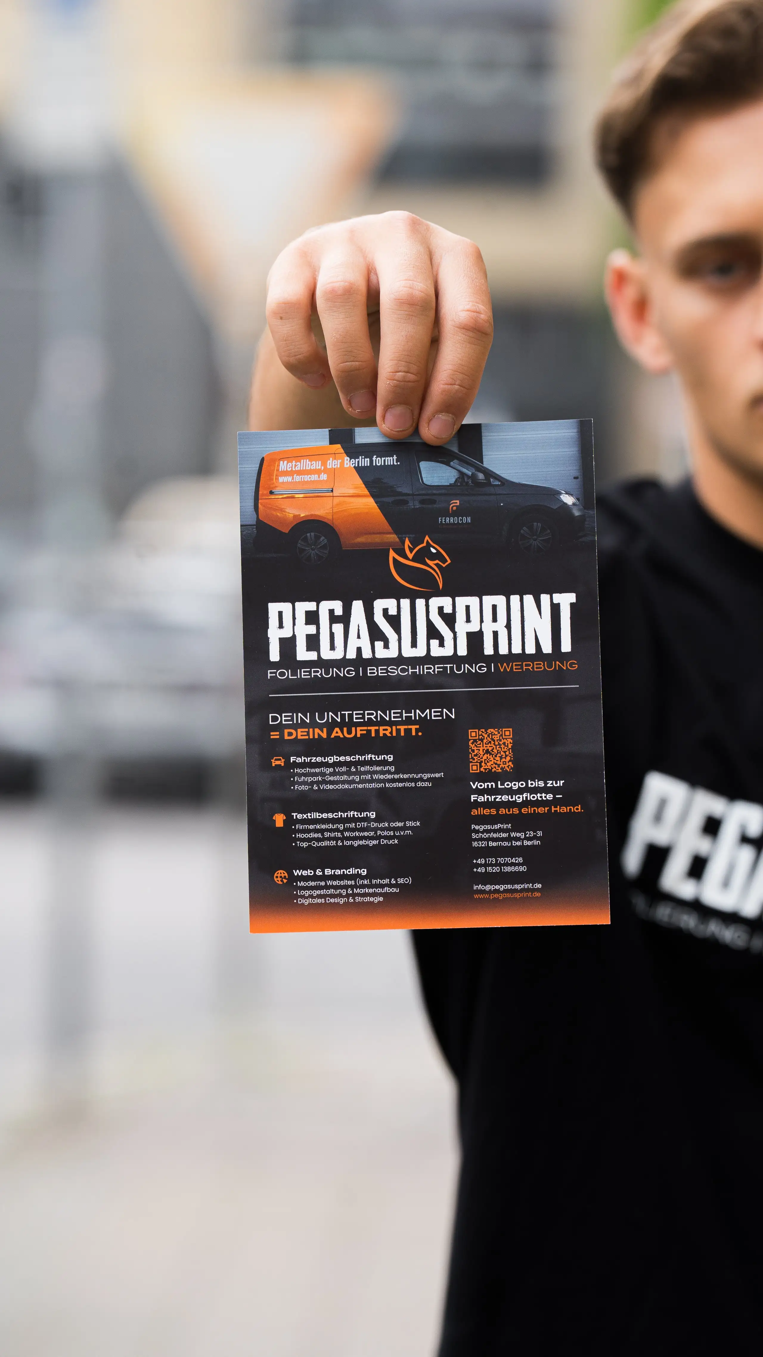 PegasusPrint Flyer mit Angebotsübersicht in der Hand